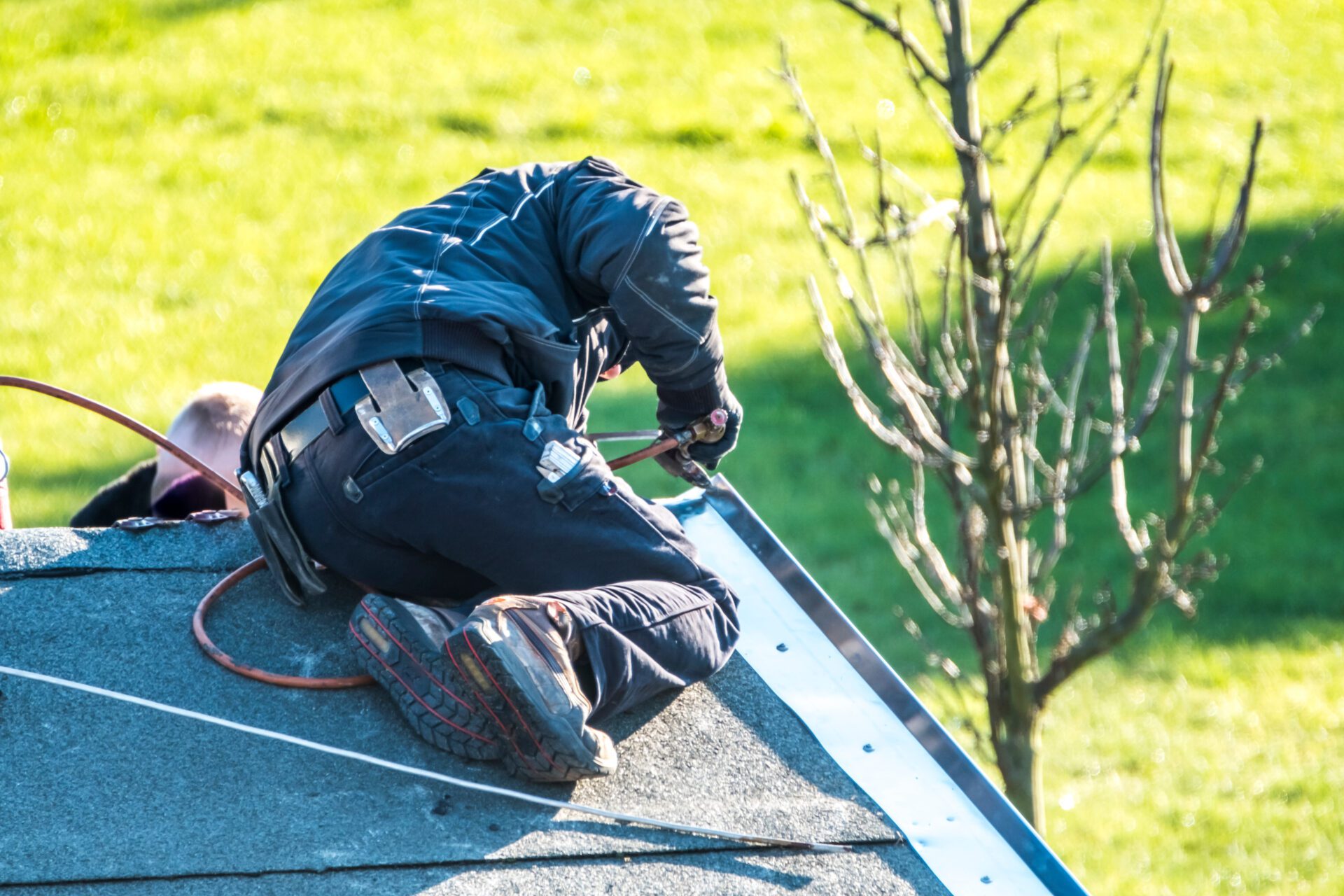 Roofer repairing the metal facing with tin after storm